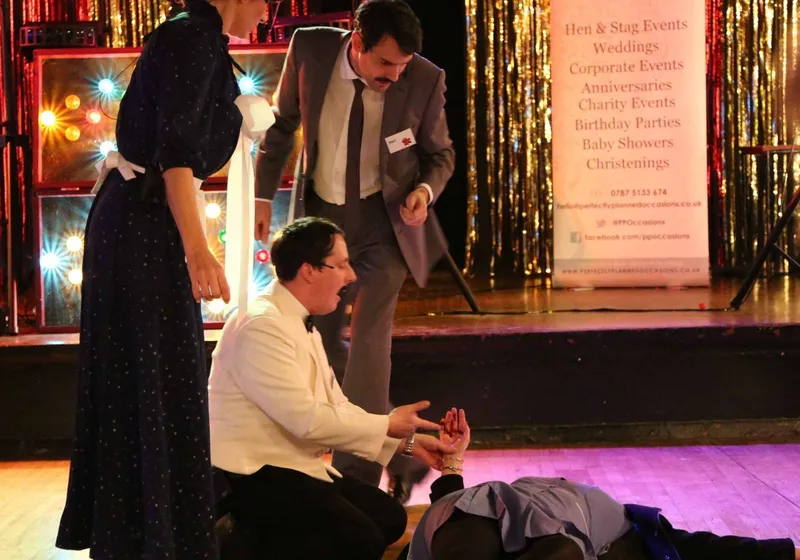 Actors performing a murder mystery scene